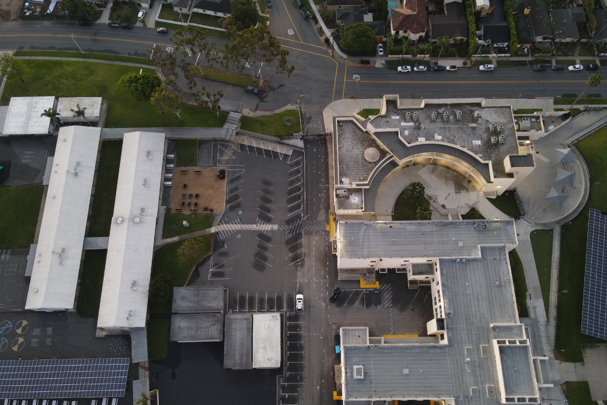 Aerial view of school facility with concrete scanning, utility mapping, solar panels, parking lots, and landscaped areas in Southern California.