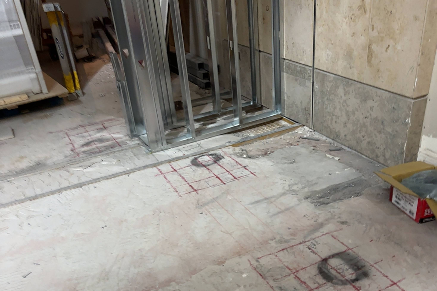 GPR concrete scanning at John Wayne Airport indoor construction site with exposed framing and marked concrete floor for utility routing and renovation work.