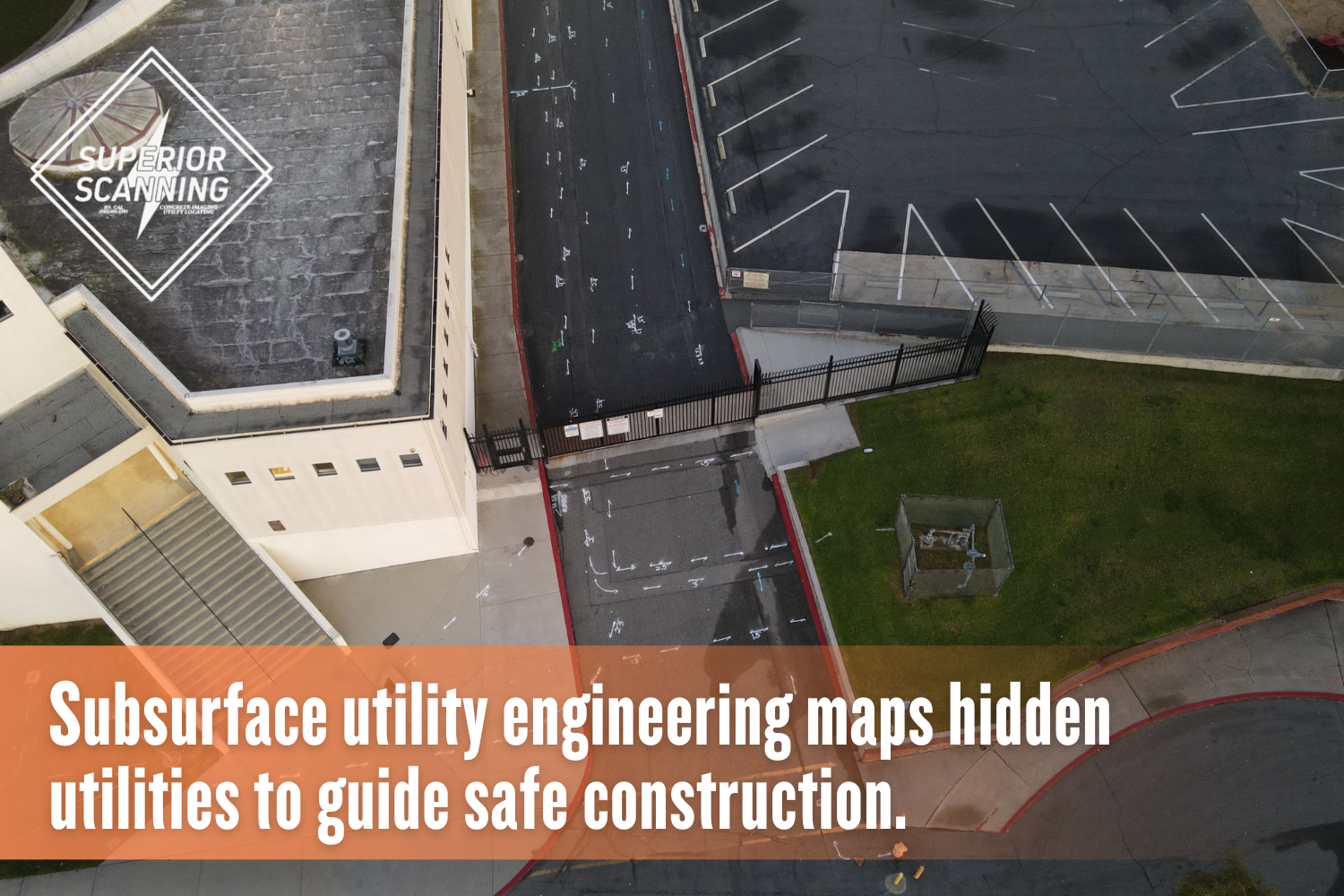 Aerial view of building complex with concrete driveway and utility markings, showing how subsurface utility engineering maps underground features for safe construction planning.