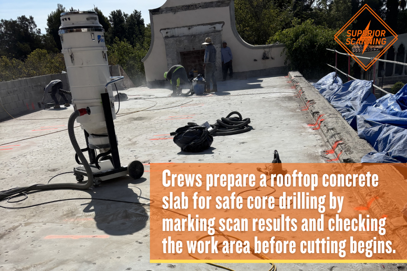 Concrete slab scanning and core drilling preparation on a rooftop with equipment, utility markings, and workers checking the surface before drilling.