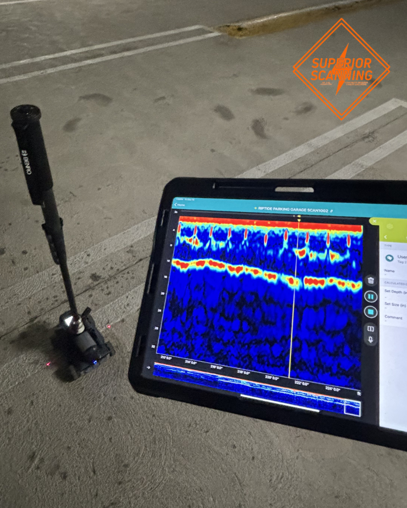 This image is fantastic because it actually shows the Ground Penetrating Radar (GPR) equipment in action, along with the real-time data being interpreted on the screen! Because the background features painted lines typical of a parking garage, this image is a perfect match for the "How Post-Tension Scanning Works" section or the "Where Are Post-Tension Cables Usually Found?" section (since parking garages are explicitly mentioned there). Here are the SEO-optimized elements for this image: File Name: post-tension-scanning-gpr-equipment.jpg Alt Text: A ground penetrating radar scanner and a tablet screen displaying real-time subsurface data during post tension scanning on a concrete parking garage slab.
