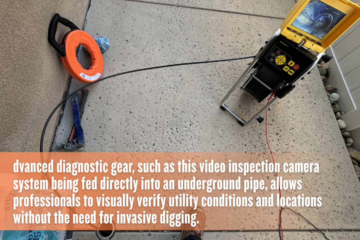 A top-down view of a concrete surface showing a black cable being fed into a small ground opening; the cable connects to a yellow diagnostic control unit with a monitor displaying the inside of a pipe, while an orange spool, pliers, and a bag of pool salt sit nearby.
