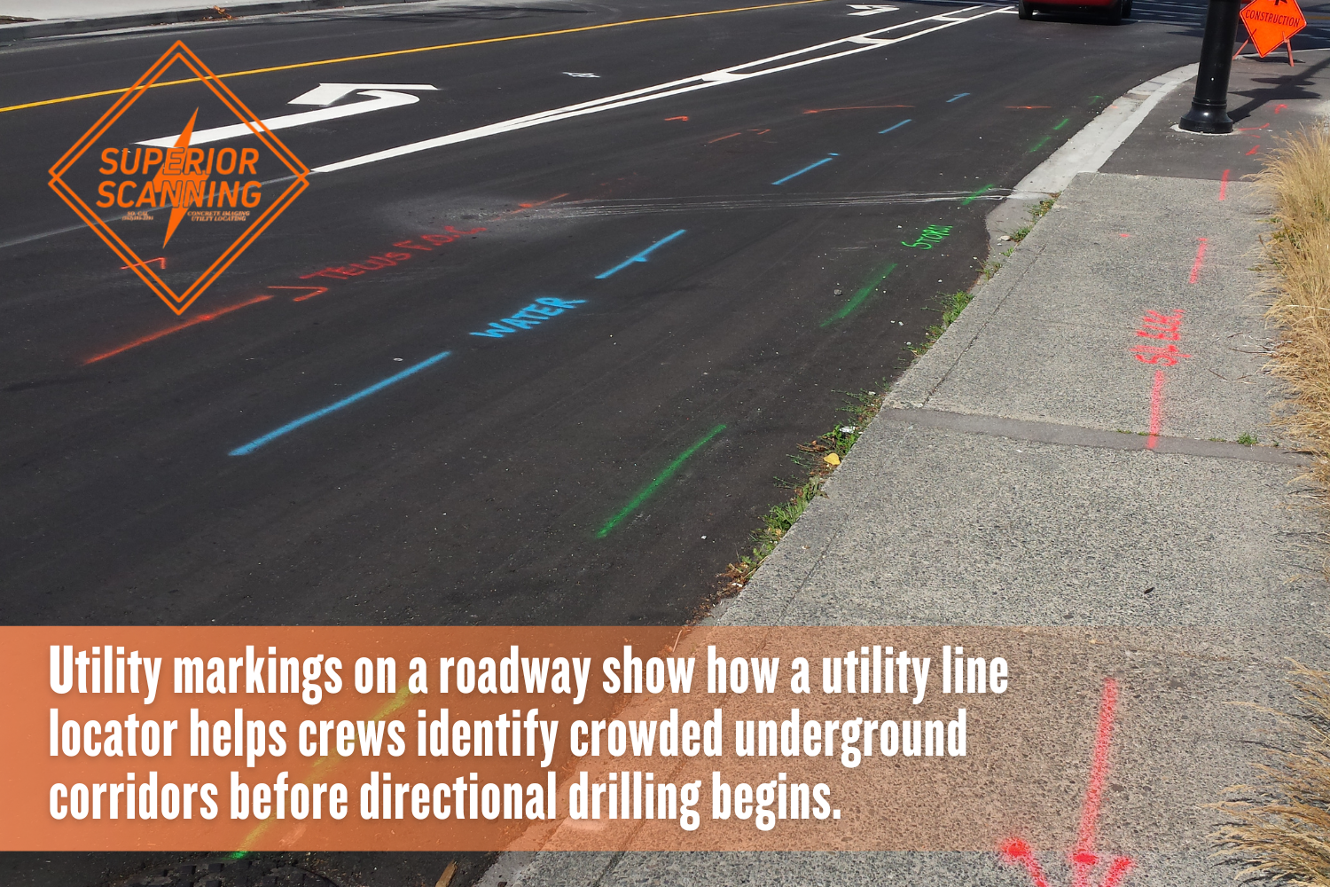 Color-coded utility markings on a street and sidewalk used to guide safer directional drilling near buried water, sewer, gas, electric, and communication lines.