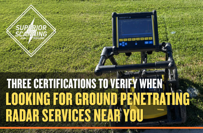 A ground penetrating radar unit with a yellow base and a black frame sits on a grassy area.