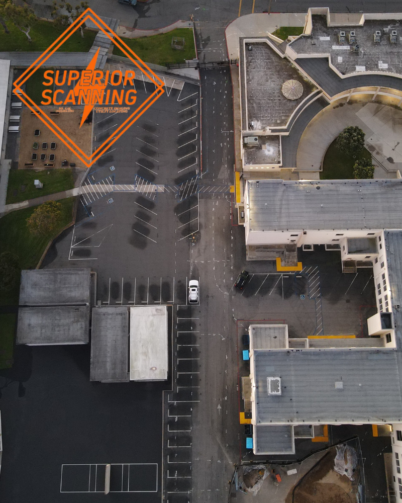 An aerial view of a school campus with buildings, parking lots, and green spaces.