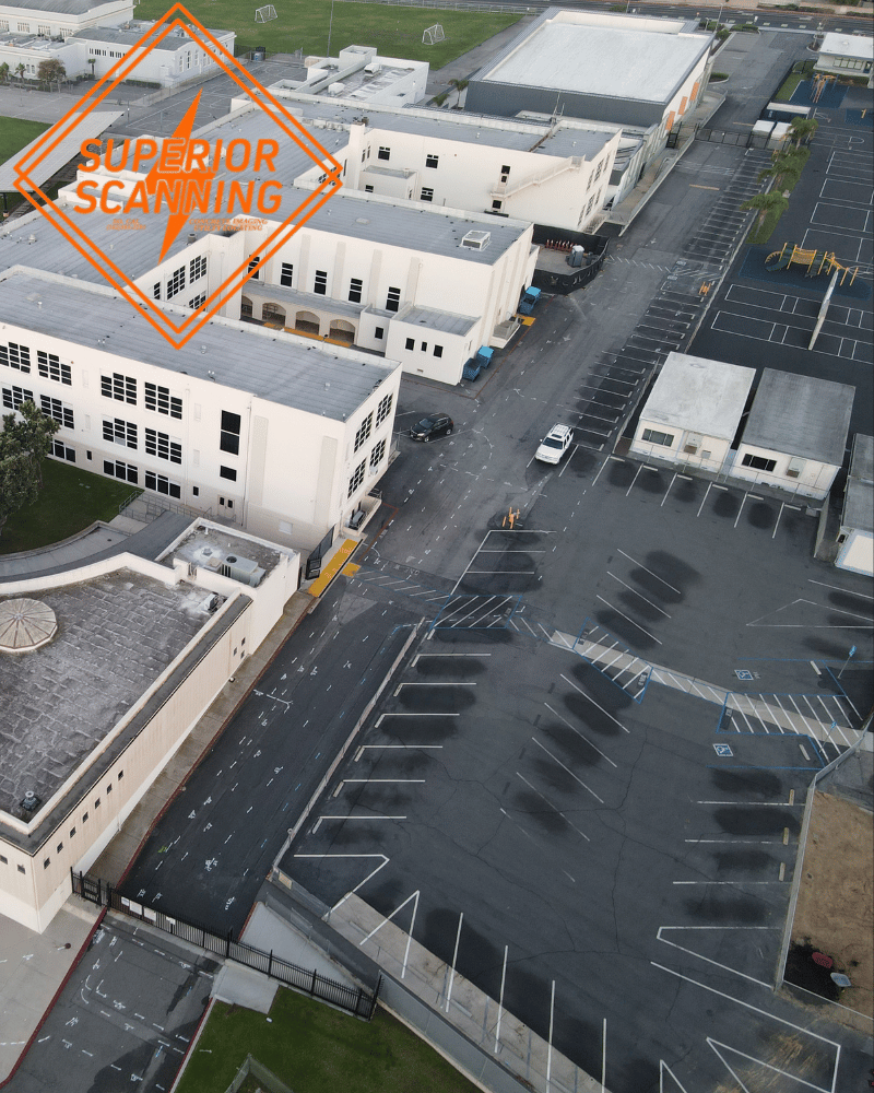 Aerial view of a school campus with multiple buildings, a parking lot, and a playground.